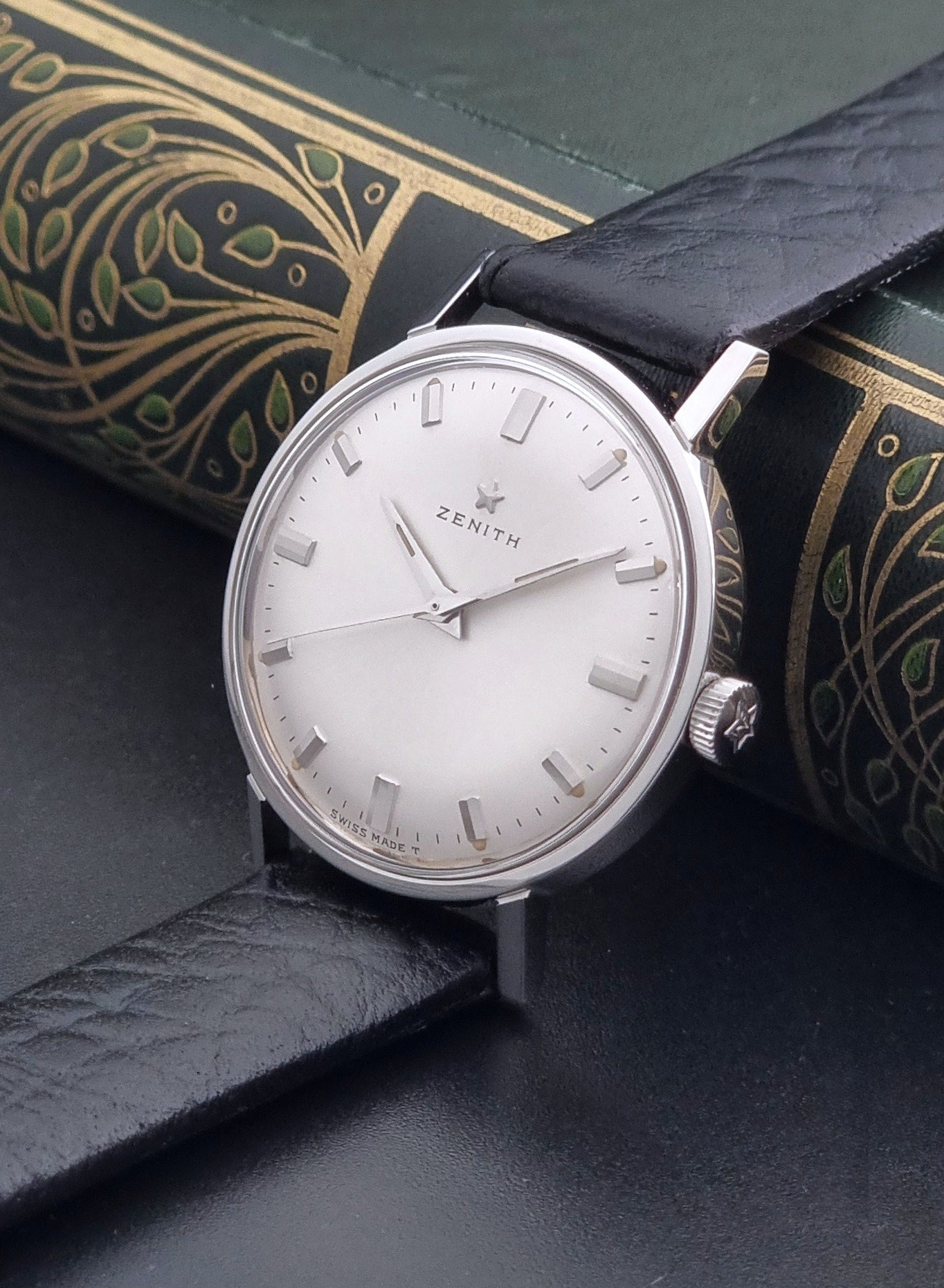 Vintage Unisex Zenith Wristwatch Manual wind with a black strap on a dark background crown view