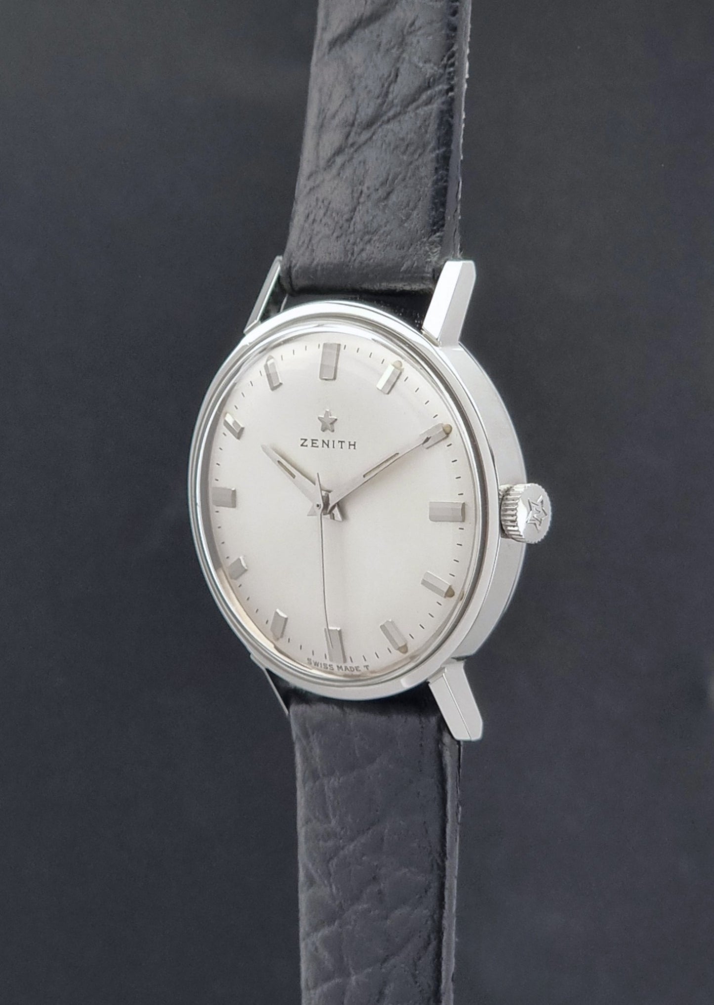 Vintage Unisex Zenith Wristwatch Manual wind with a black strap on a dark background crown profile view