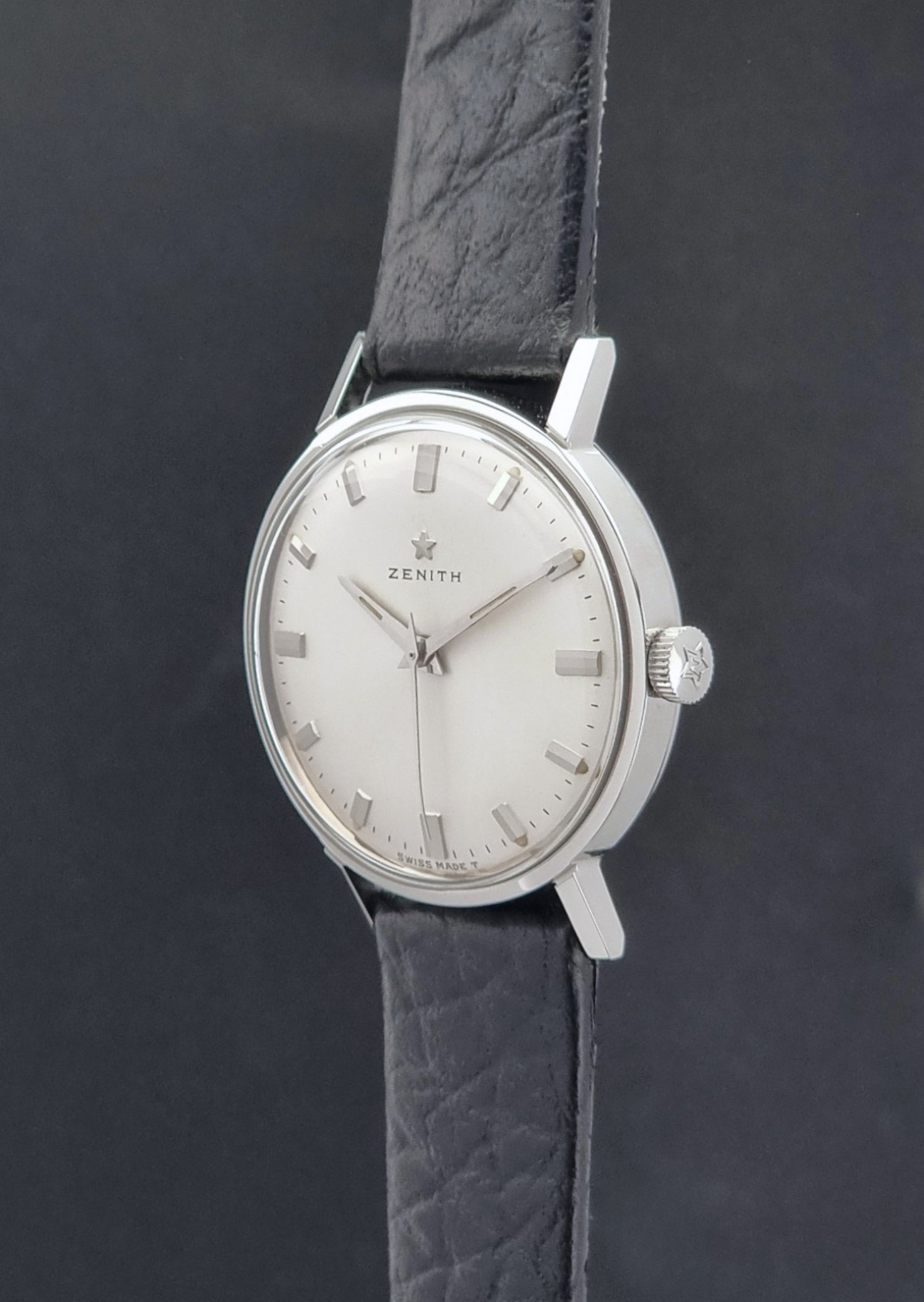 Vintage Unisex Zenith Wristwatch Manual wind with a black strap on a dark background crown profile view